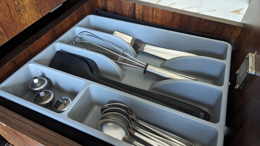 whisk, spoons, forks, spatula in a tray