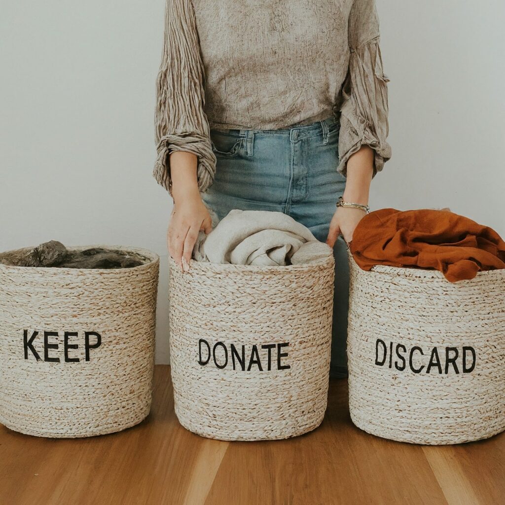 3 baskets with labels KEEP,DONATE,DISCARD with clothes inside these baskets