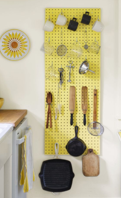 Peg board in kitchen hung on wall with cutlery