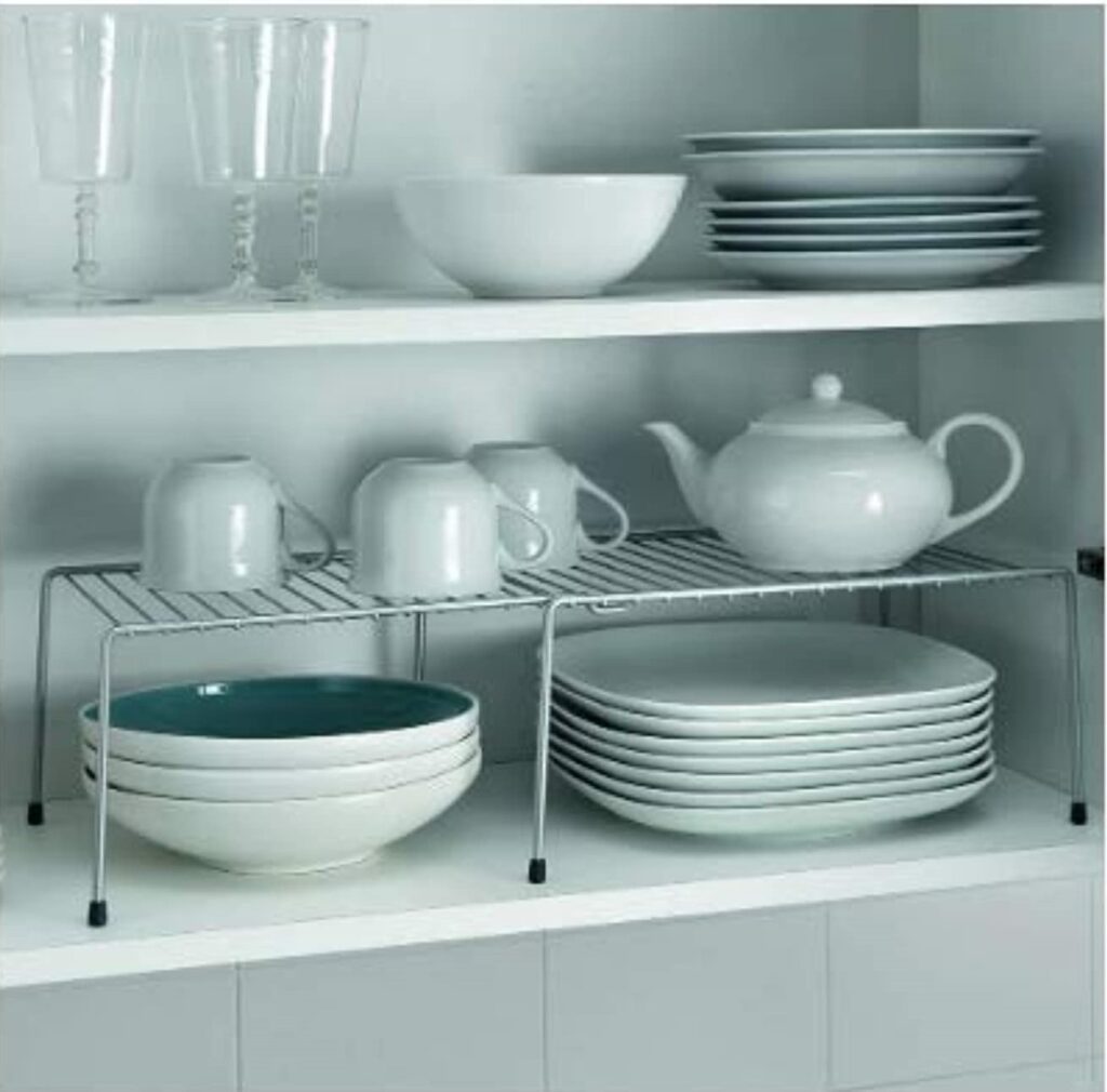 Shelf riser in the kitchen cabinet with plates, cups , glasses