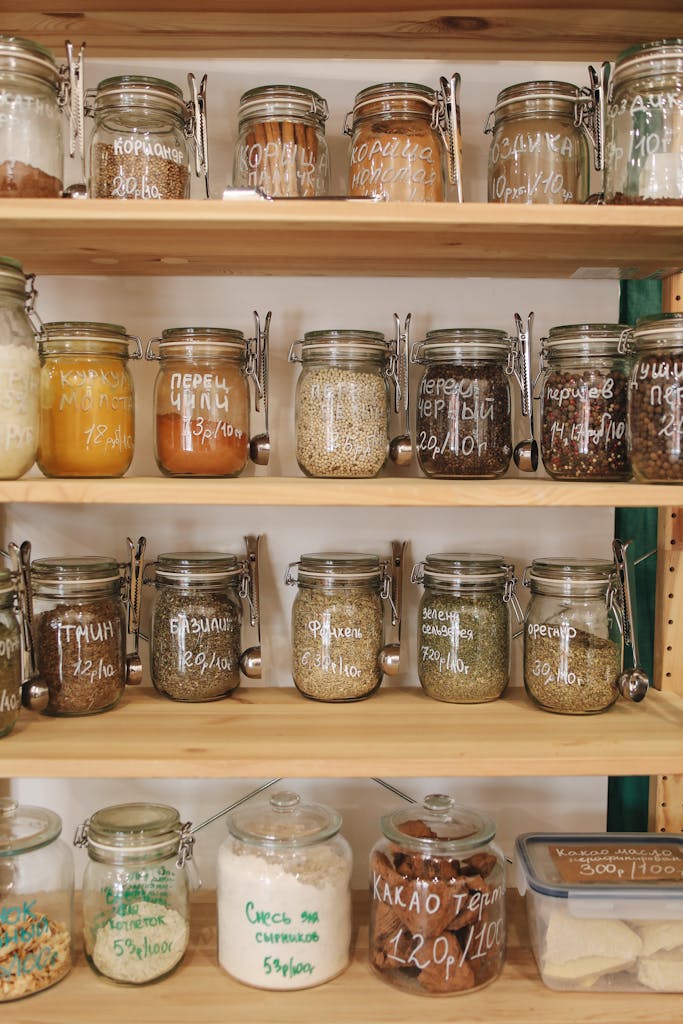 Glass jars filled with various spices and ingredients on wooden shelves promoting zero waste lifestyle.