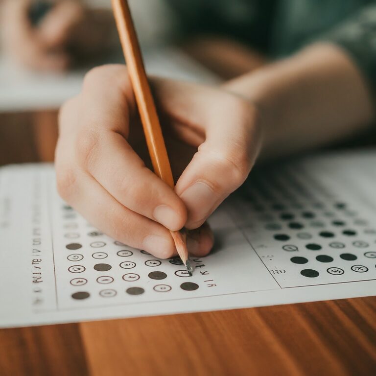 Person taking a quiz, holding a pencil marking radio buttons