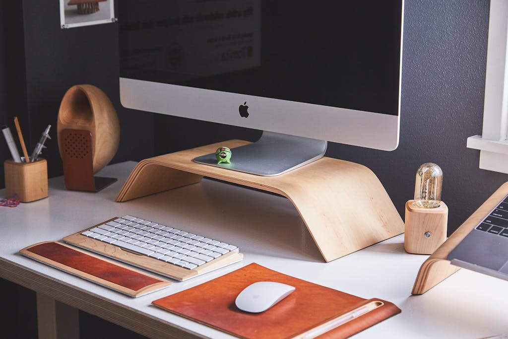 Turned-off Silver Imac, organized desk with mouse pad, keyboard, mouse, light